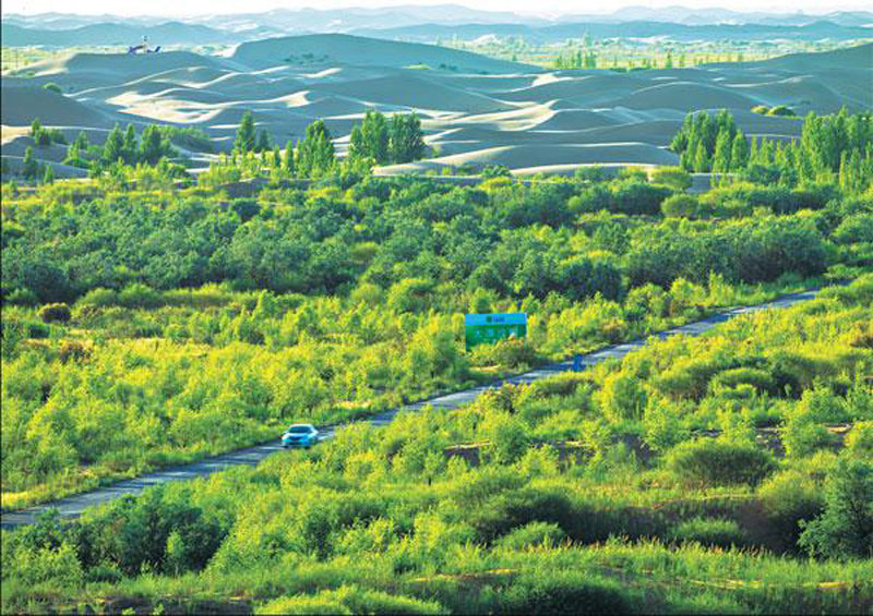 Une route verte traversant le déser au nord de la Chine