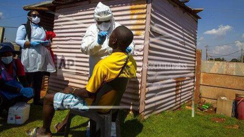 Health workers collects samples for coronavirus testing outside a shack, during the screening and testing campaign aimed to combat the spread of COVID-19 at Lenasia South, south Johannesburg, South Africa, Tuesday, April 21, 2020. /AP