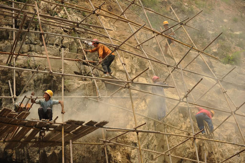 À Badong, des ouvriers réparent un site endommagé par des changements sismiques probablement induis par le projet du barrage des Trois Gorges. Photo par Peter Parks / AFP.
